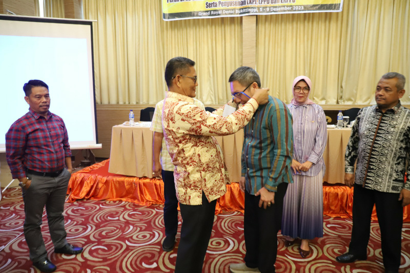 Ketua DPRD Padang pasangkan tanda peserta bintek kepada anggota dewan.